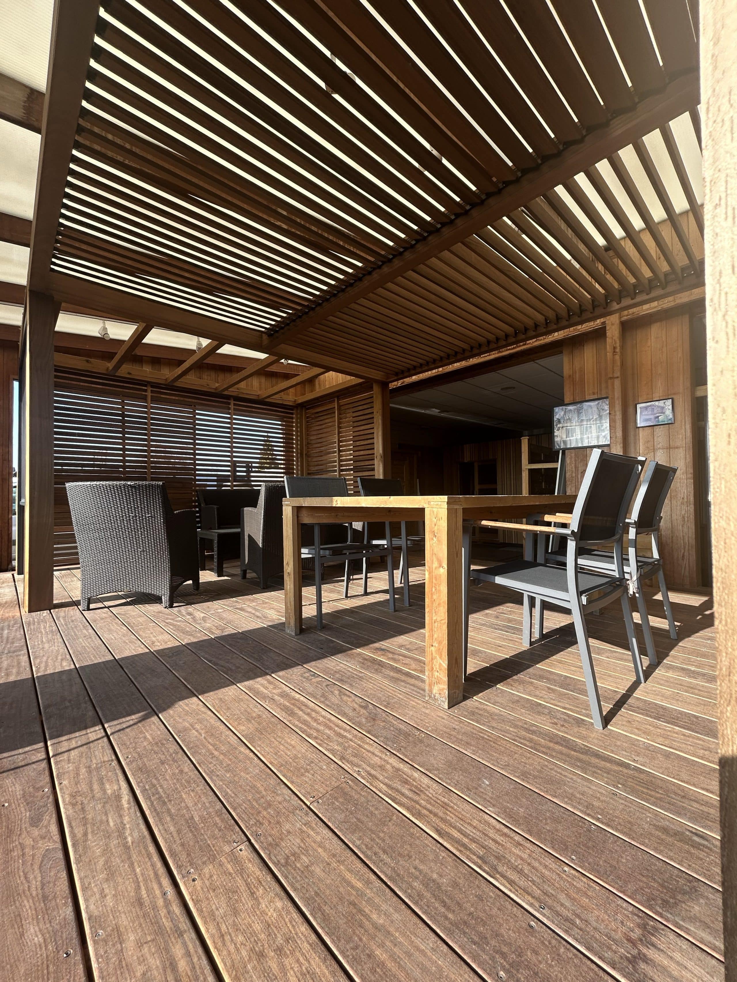 Pergola bioclimatique en bois d'Ipé avec mobilier extérieur sur terrasse en bois