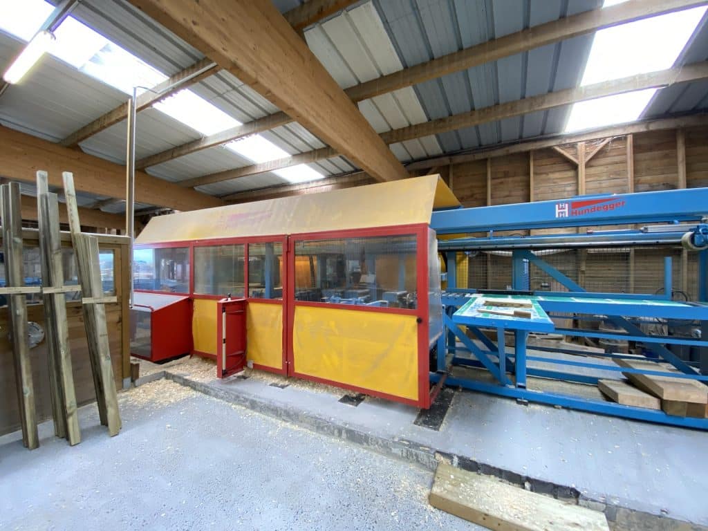Atelier scierie machine jaune rouge — equipe au travail