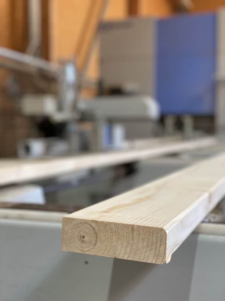 Montant de bois raboté clair en sortie de machine d'usinage à commande numérique en atelier