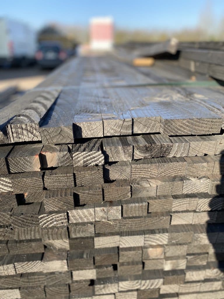 Paquets de lames de bois vert fraîchement traité empilées sur le parc de stockage extérieur